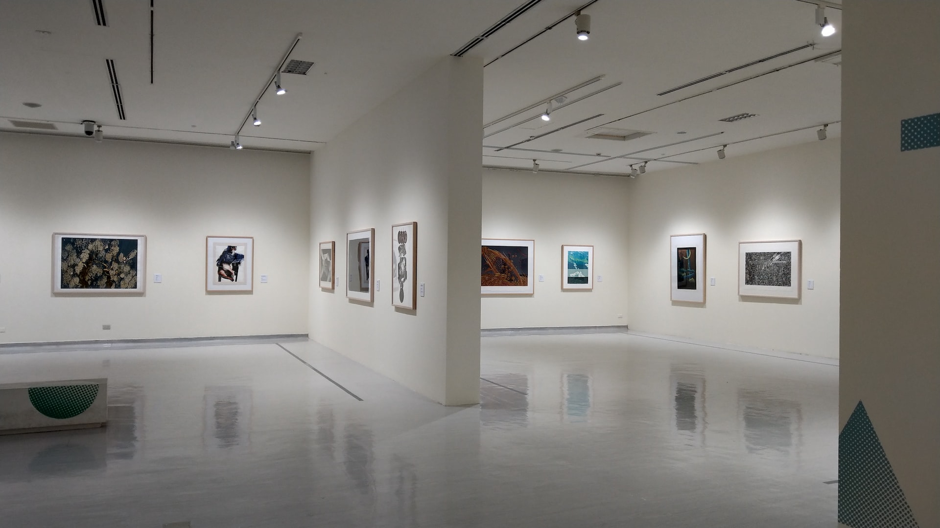 white wall with paintings on wall